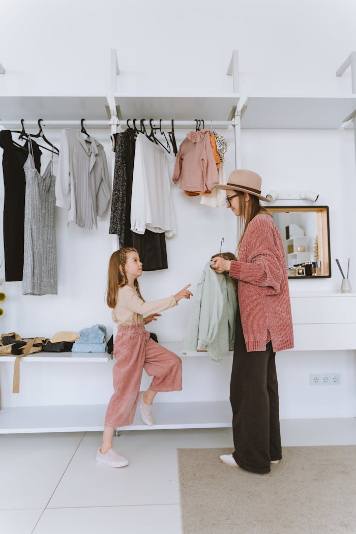 about-us-01 A mother and daughter enjoy a bonding moment while choosing outfits in a stylish modern closet.